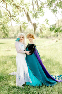 elsa and anna posing for a photo with fairest of all parties 