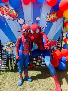 spiderman for hire posing next to the birthday boy