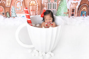child smiles in a hot cocoa mug